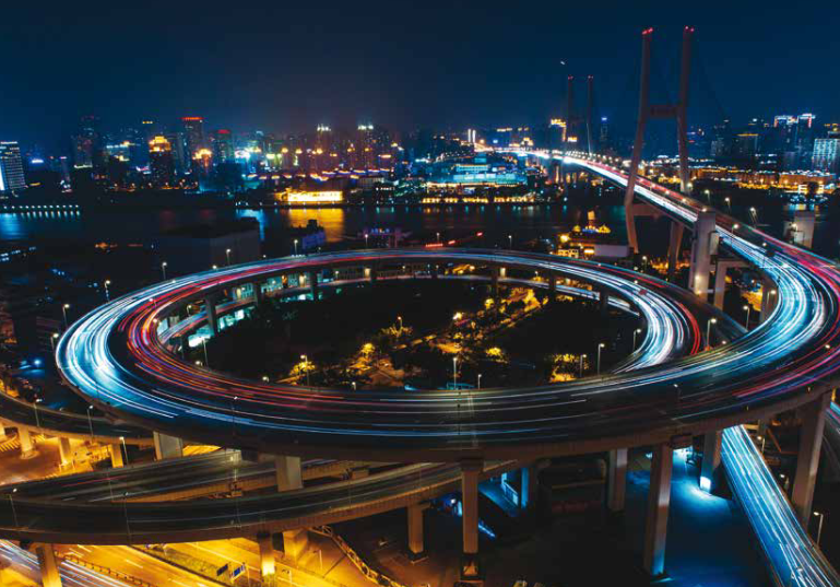 image of a highspeed curved road with blurred traffic lights  